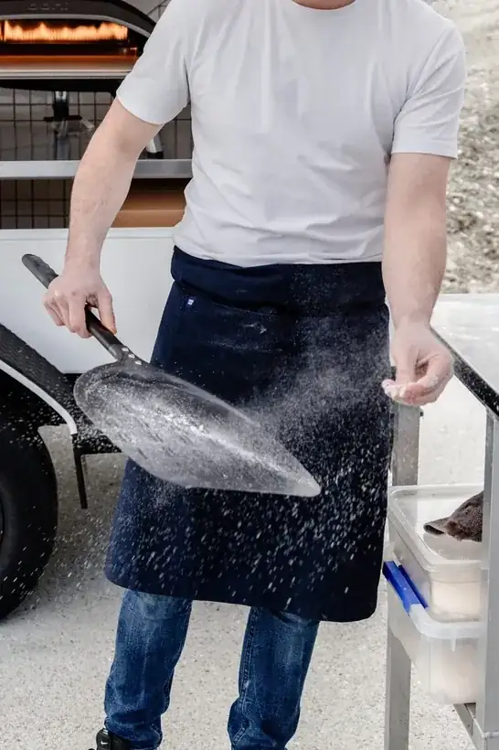 Biga chef launching a pizza into the wood-fired oven with a peel