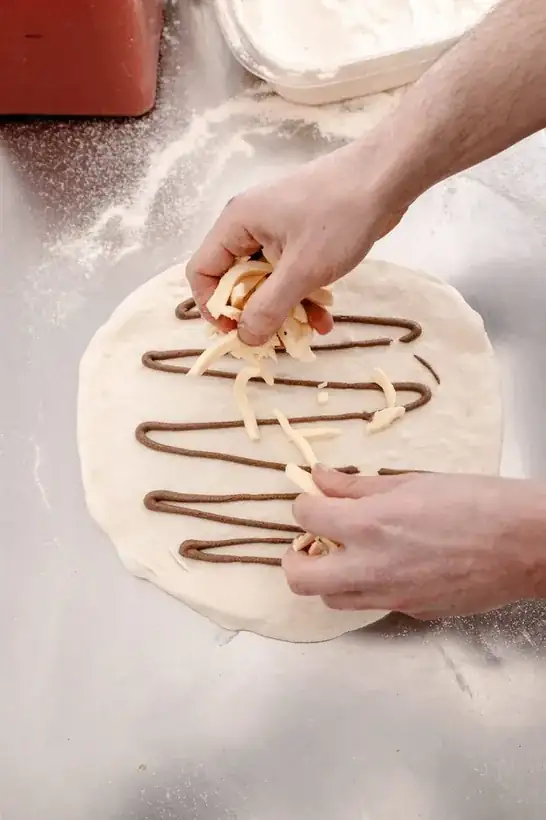Hands preparing a Nutella calzone with mascarpone stripes