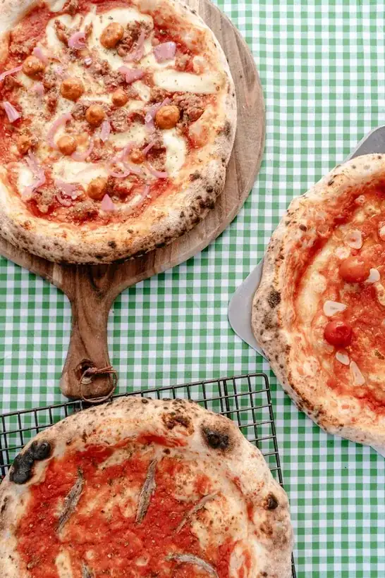 Wood-fired pizzas cooling on a rack at a Queenstown market